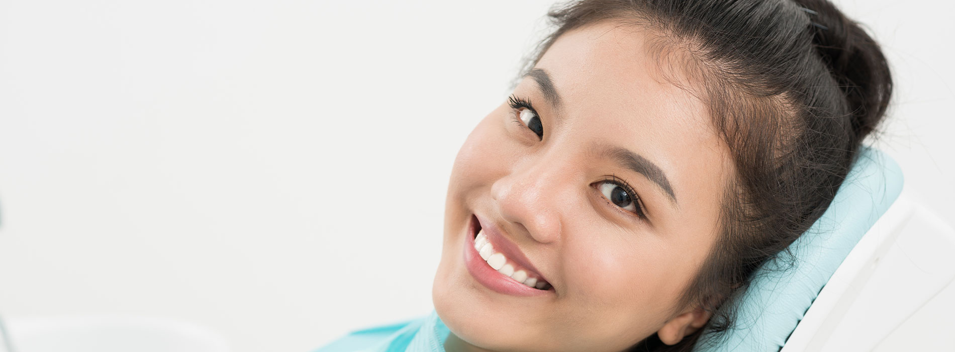 A well-lit reception area with a desk, computer monitor, and potted plant.
