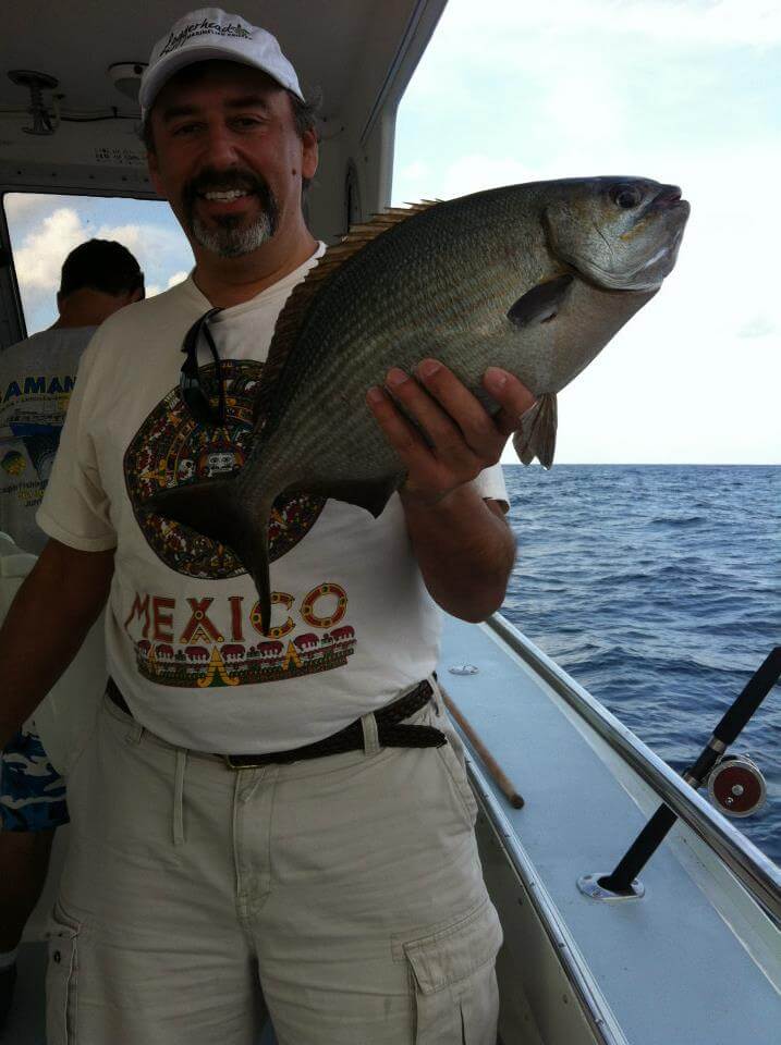 Dr. Villalobos holding a fish on a boat