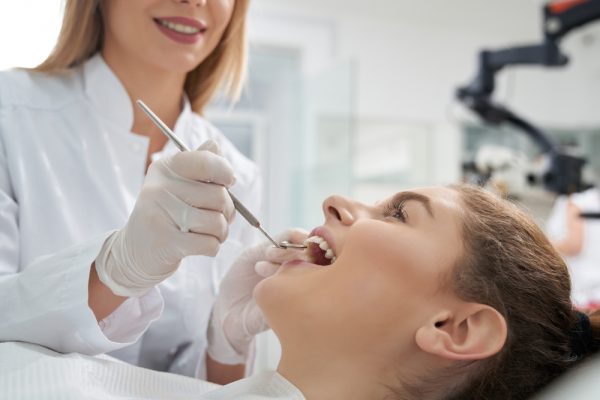 young woman getting her teeth examined at the dentist.