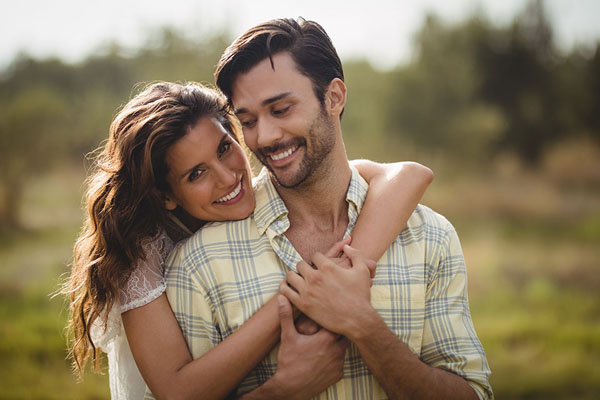 Young couple smiling and embracing outdoors
